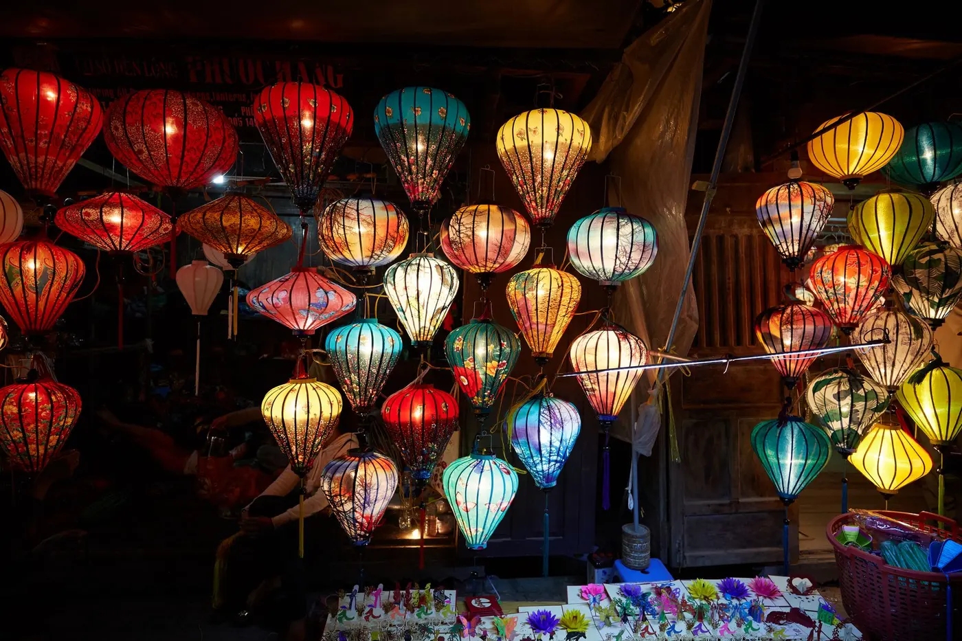 Rows of red and gold silk lanterns hanging above a market stall