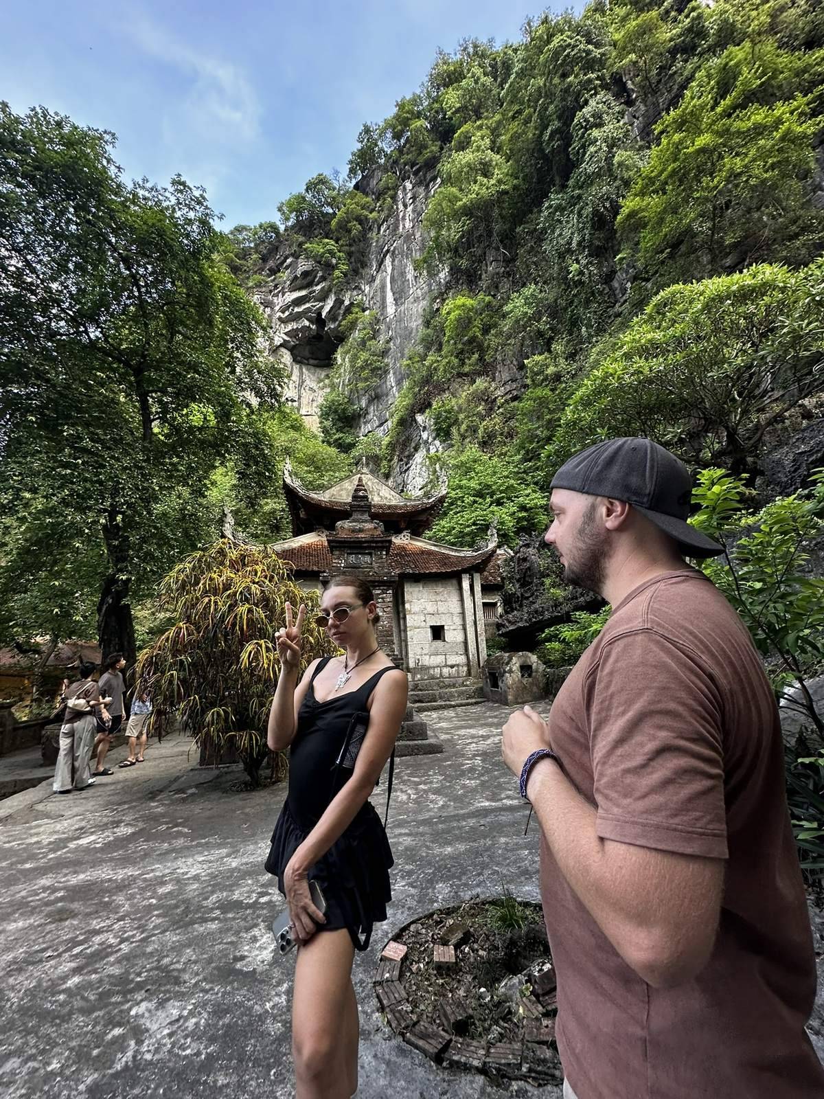 Travelers standing in front of a cliffside pagoda near Ninh Binh