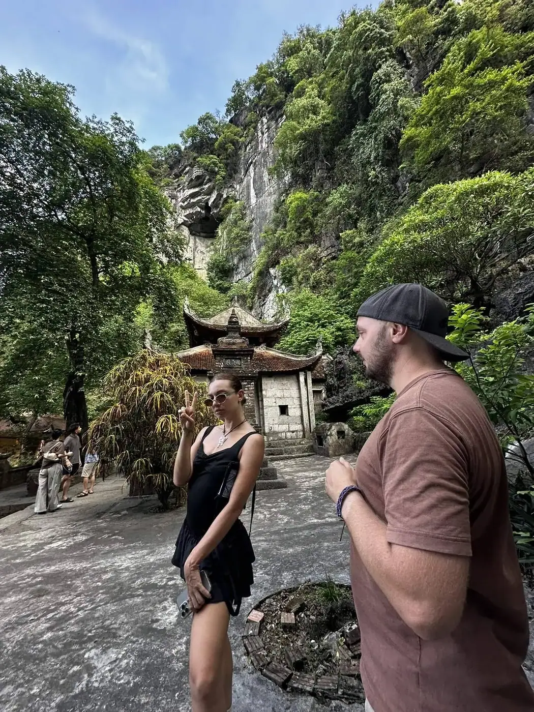 Travelers standing in front of a cliffside pagoda near Ninh Binh