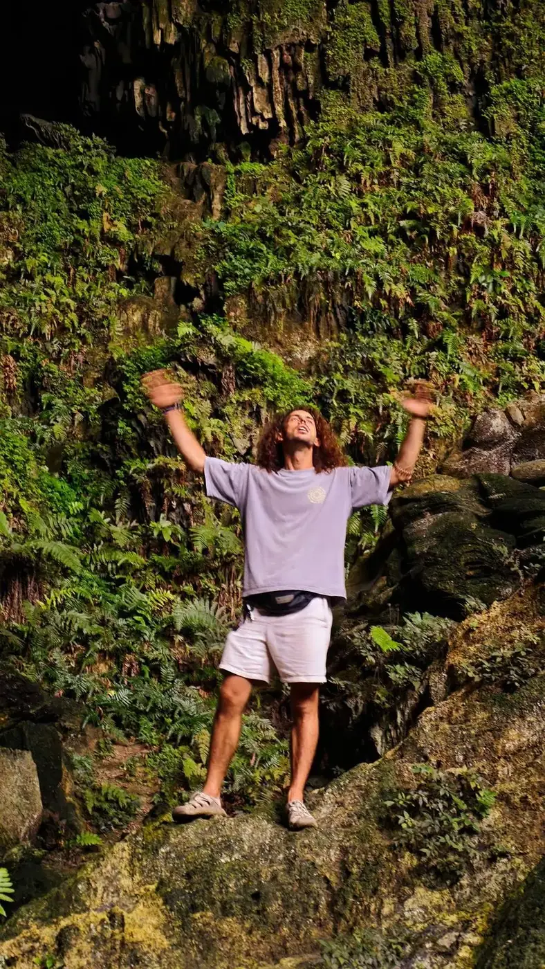 Hiker celebrating at the top of the Mua Cave viewpoint climb