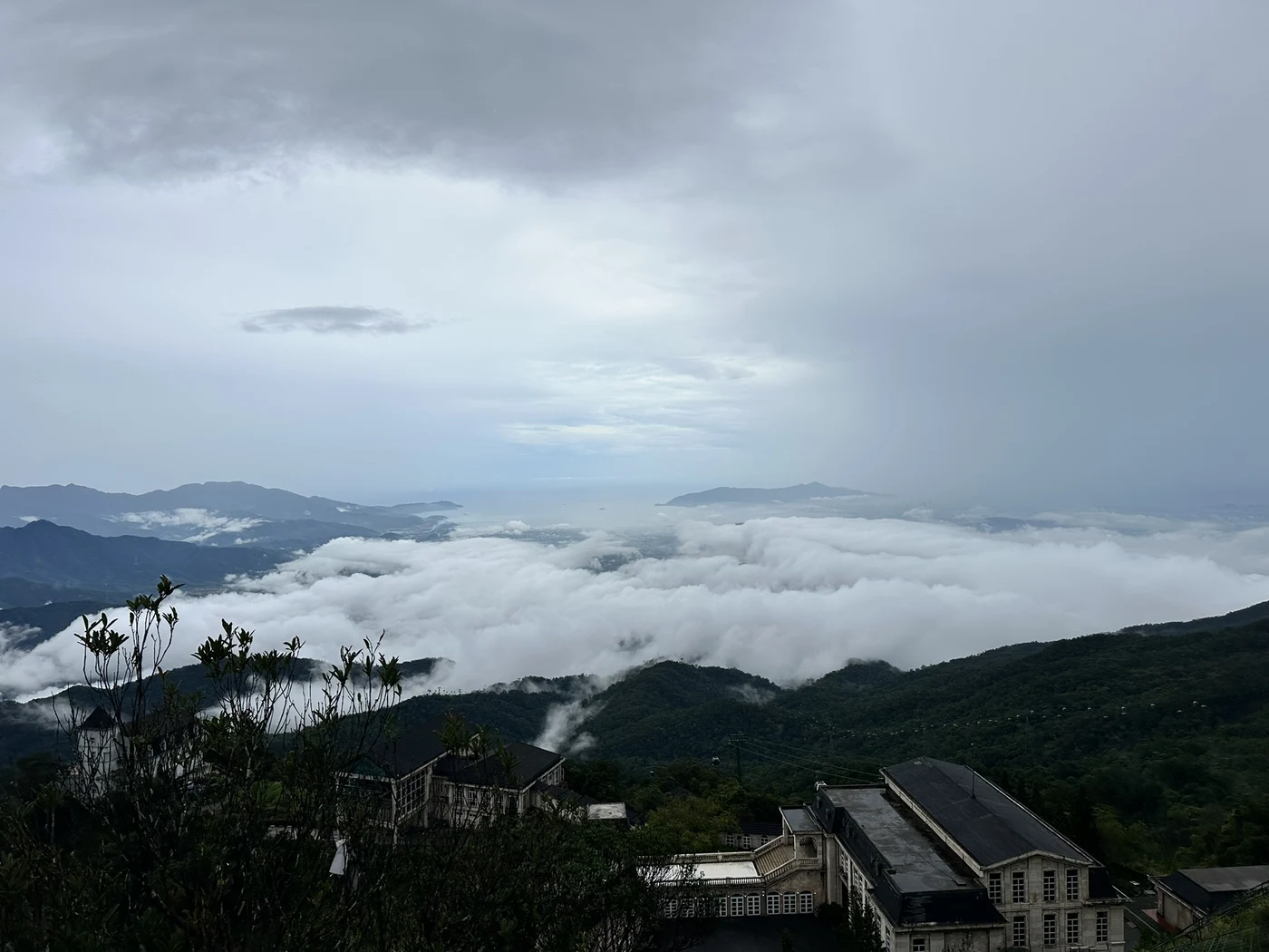 Sea of clouds over mountains and colonial-style buildings on a viewing platform