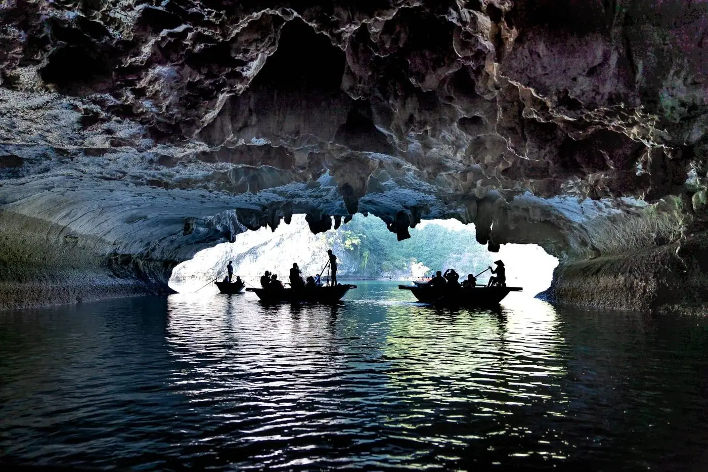 Boats crossing an underground river at a cave mouth in Vietnam