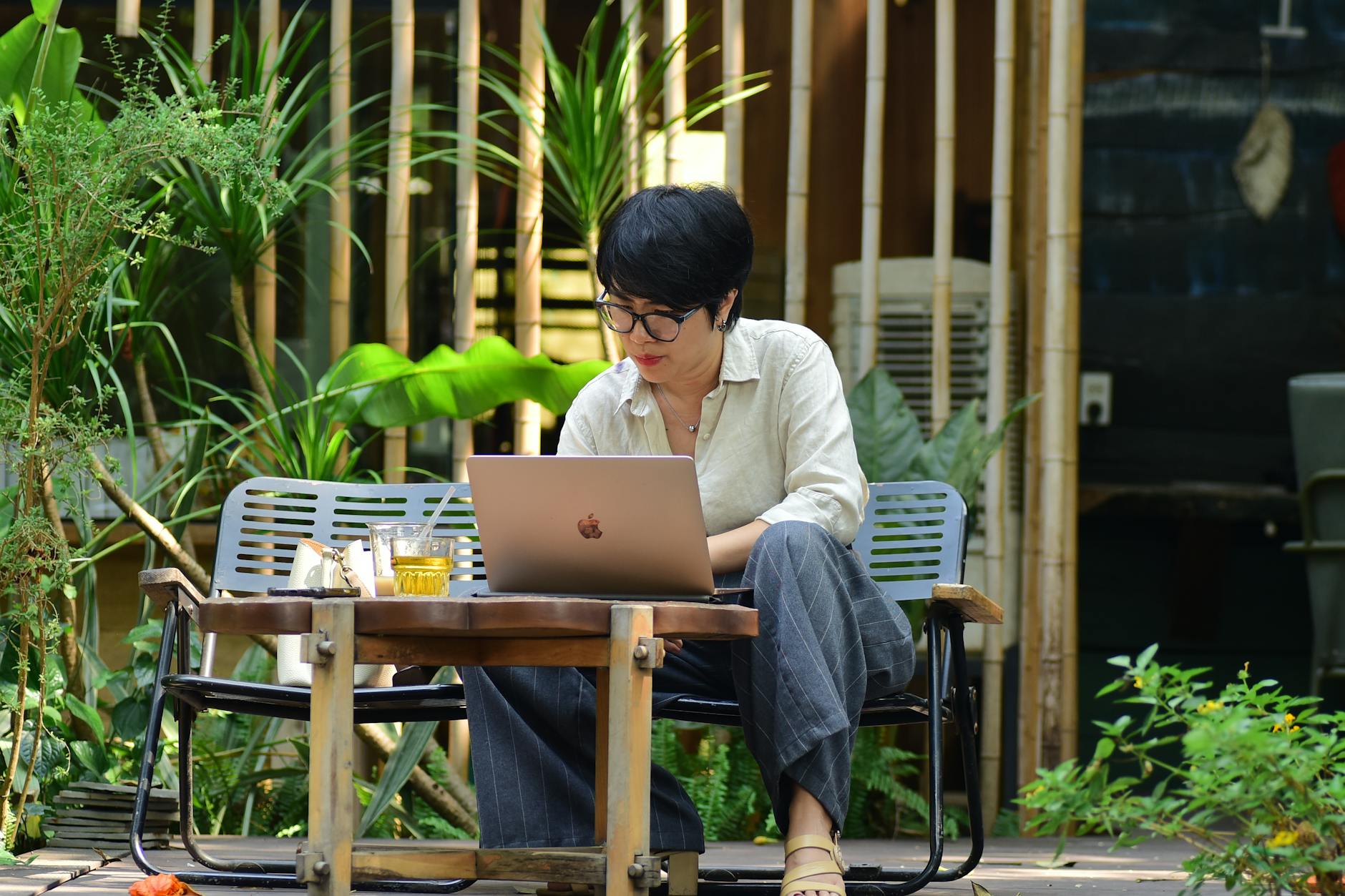 Female digital nomad working from a laptop in a tropical Vietnamese cafe