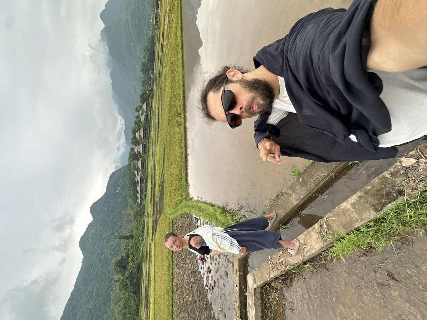 Mai Chau mountains rice fields — couple on viewpoint with mountain backdrop and misty valley of flooded rice fields