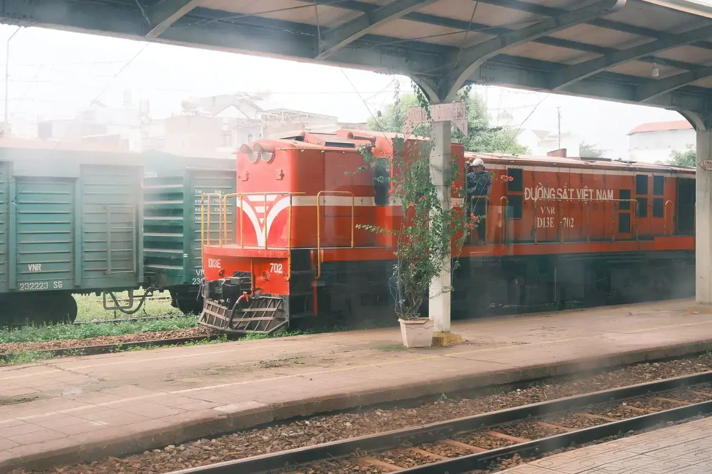 A red Vietnam Railways locomotive marked Duong Sat Viet Nam parked at a station platform