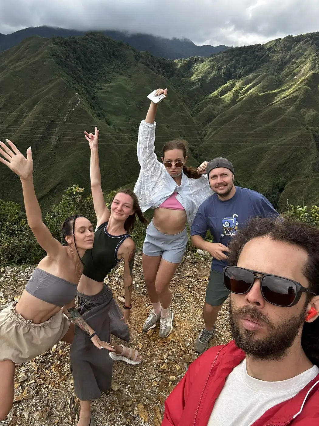 A group of five travelers posing on a mountain viewpoint in Vietnam
