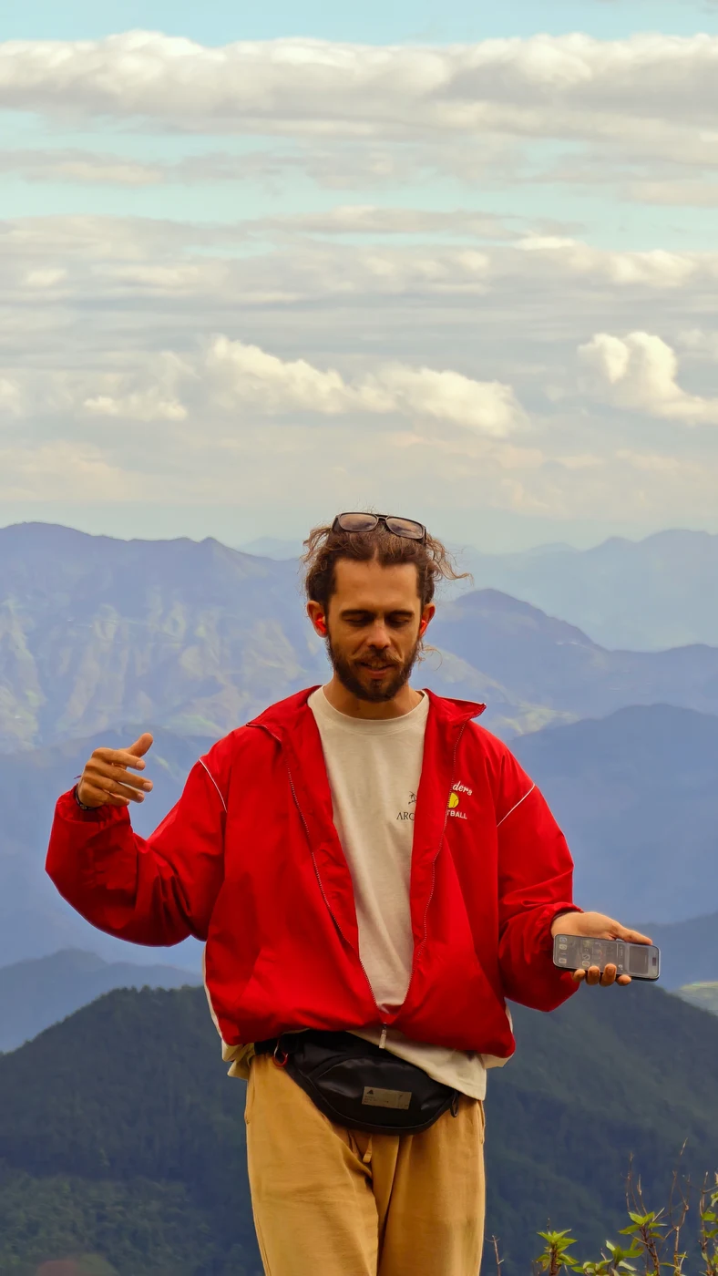 Portrait of a traveler in a red jacket at a mountain viewpoint