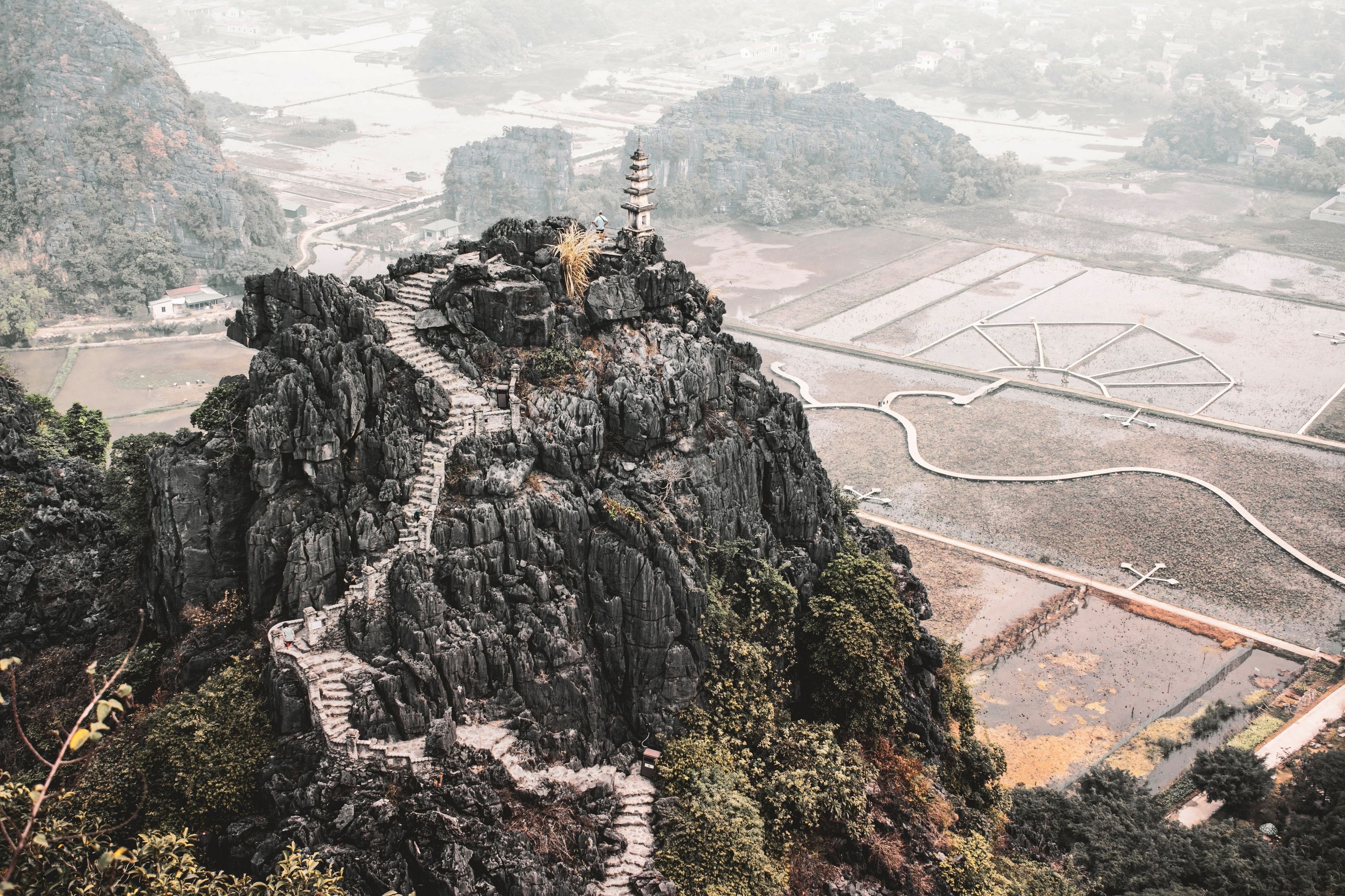 Stone stairway climbing to the Hang Mua viewpoint pagoda above rice fields