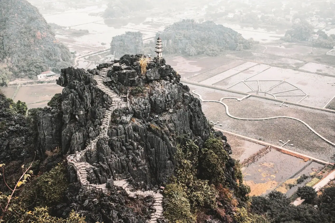 Stone stairway climbing to the Hang Mua viewpoint pagoda above rice fields