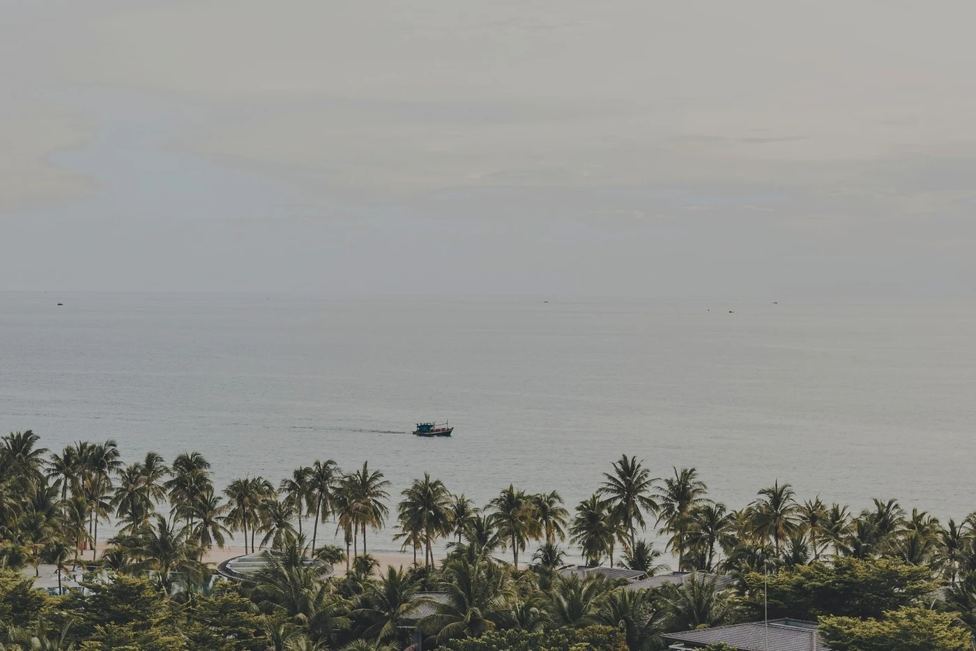 Palm-lined beach with a fishing boat off Phu Quoc island