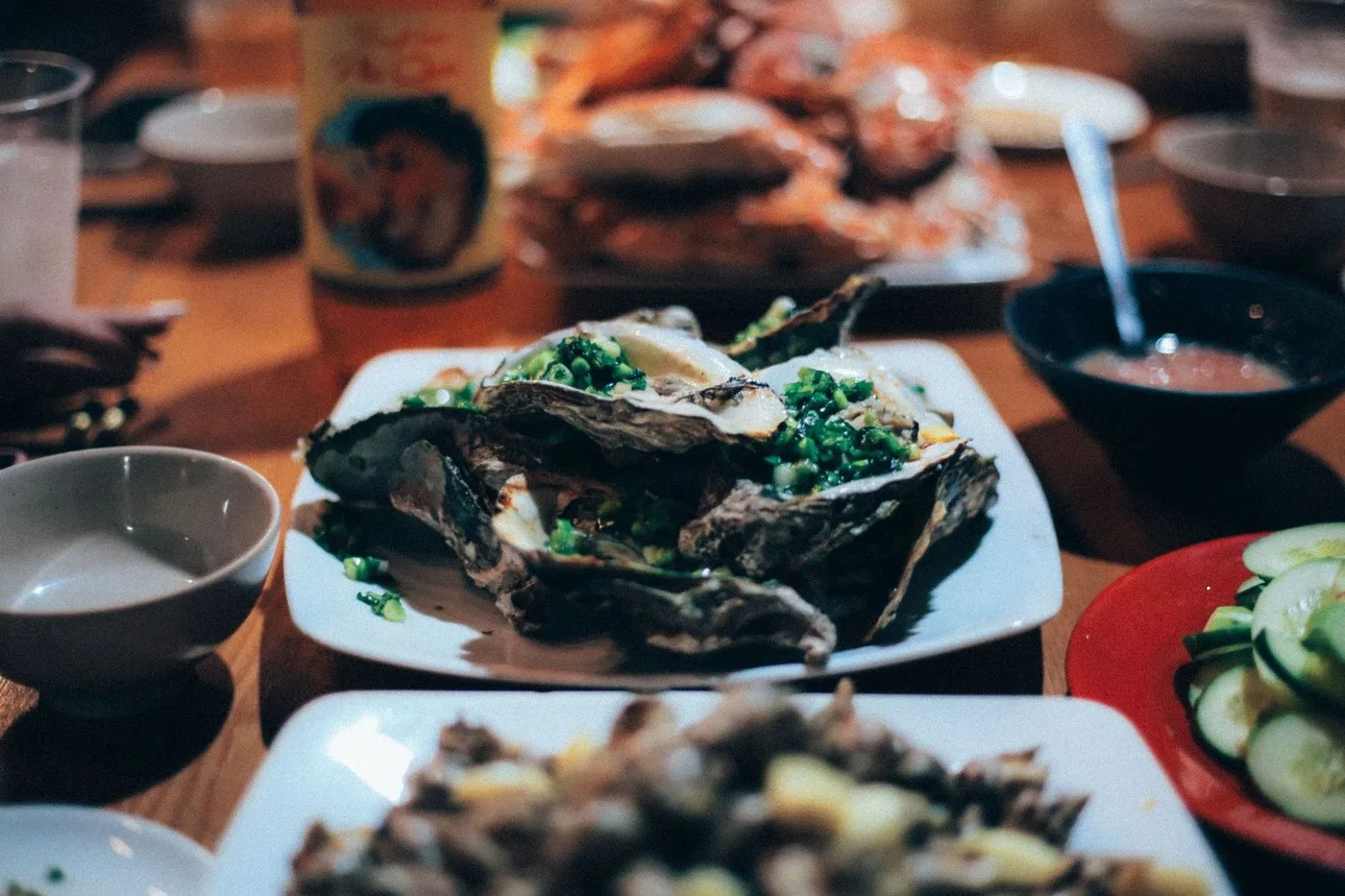 Grilled oysters and seafood platter at a Vietnamese restaurant table