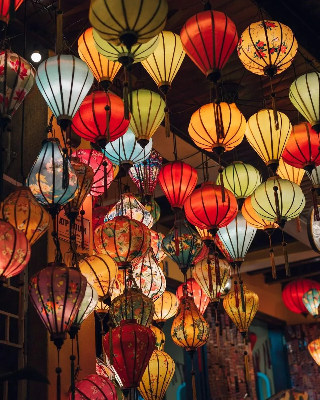Silk lanterns of many colours and floral patterns hanging tightly together
