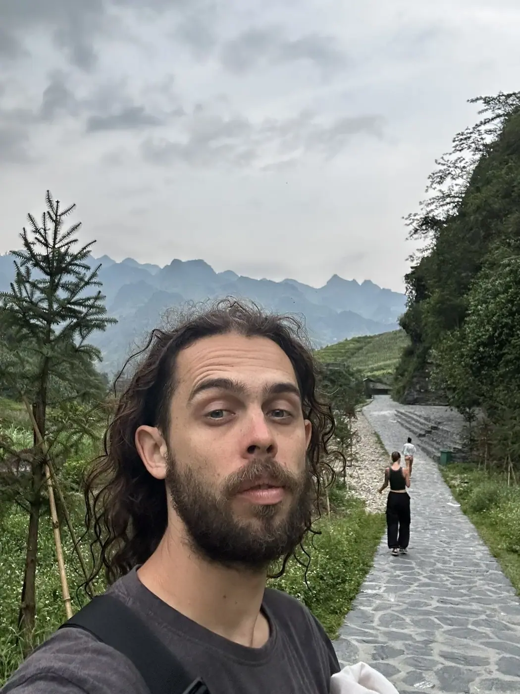 Traveler on a mountain trail with companions in Vietnam