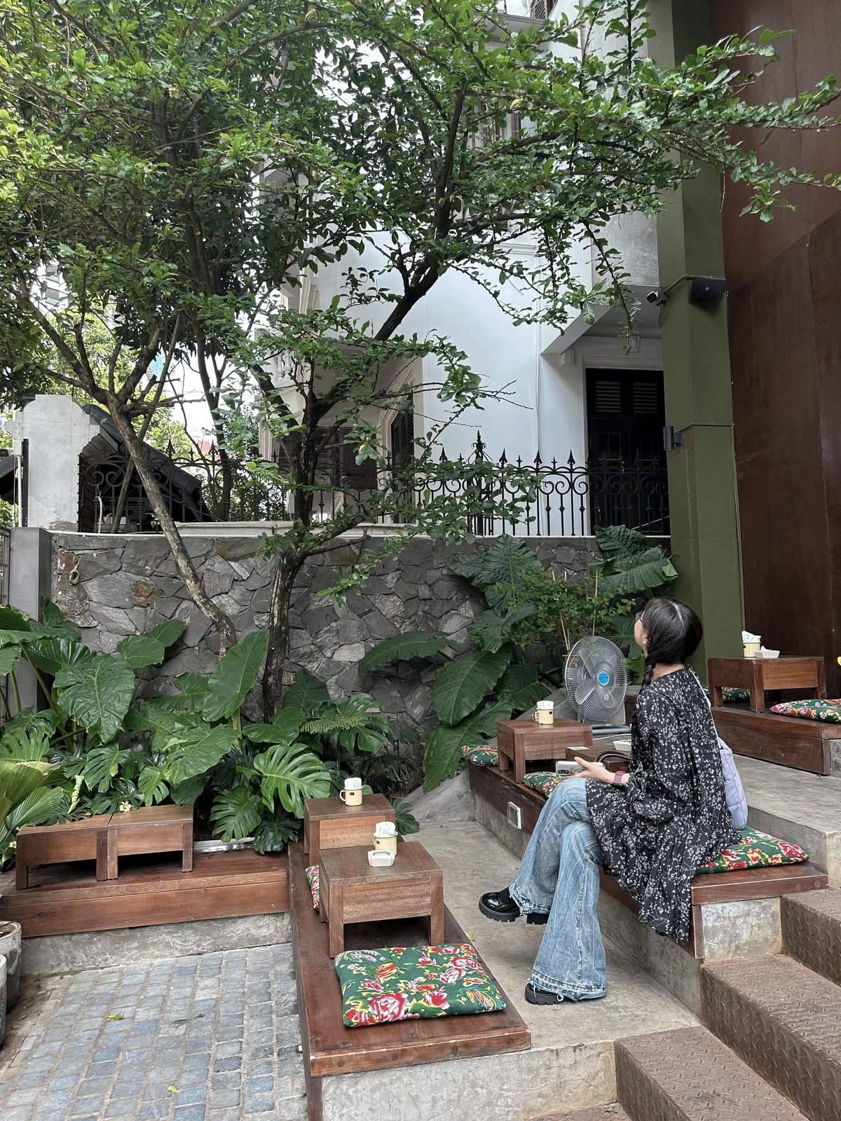 A woman resting at a quiet outdoor cafe in Da Nang in the evening