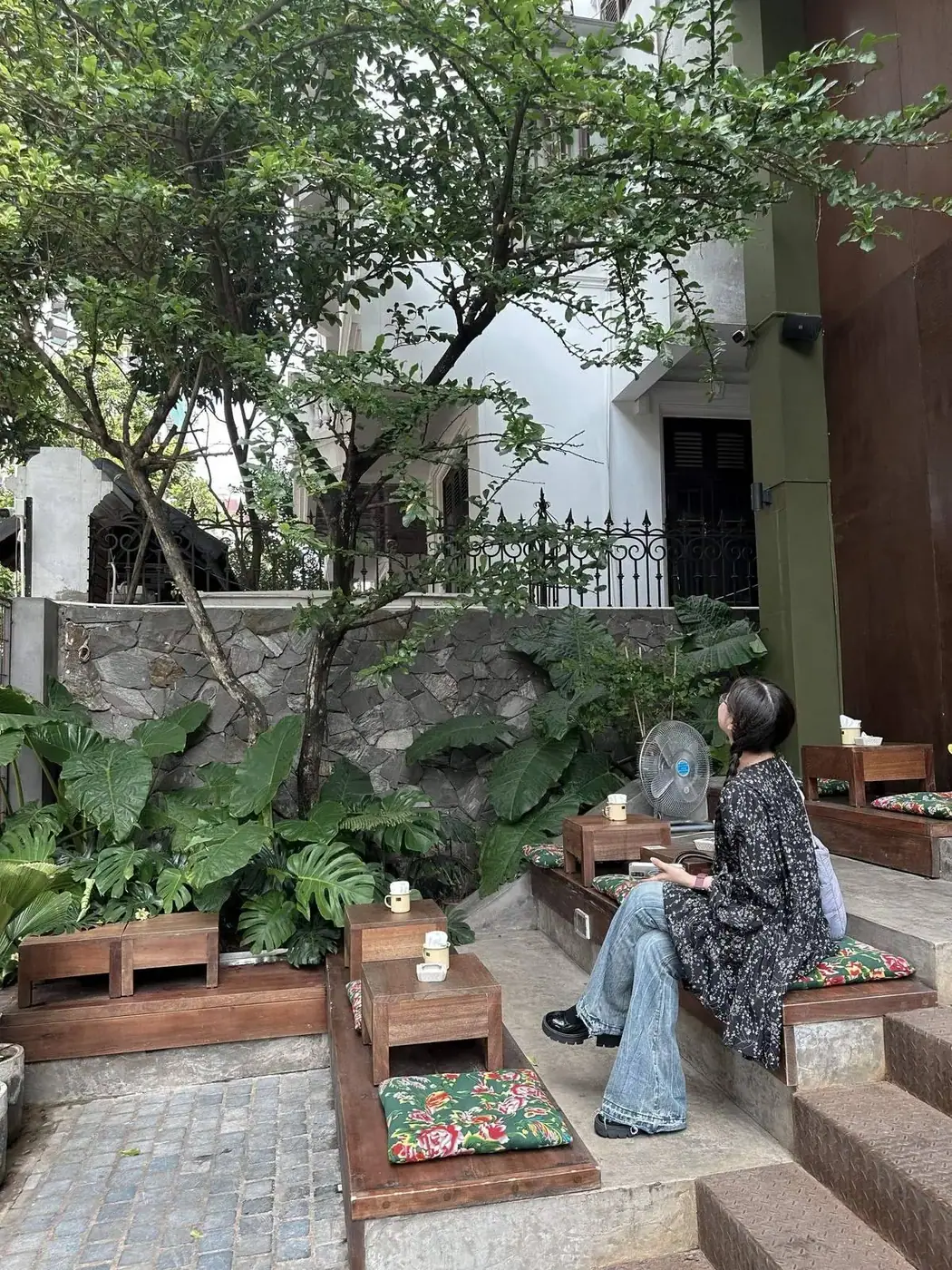 A woman resting at a quiet outdoor cafe in Da Nang in the evening