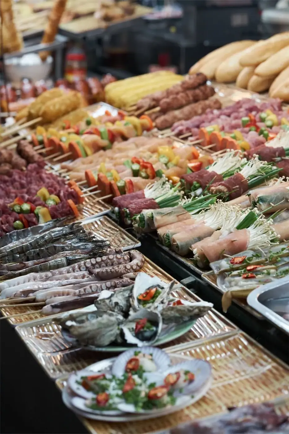 Skewered meat and seafood laid out at a Da Nang street food stall
