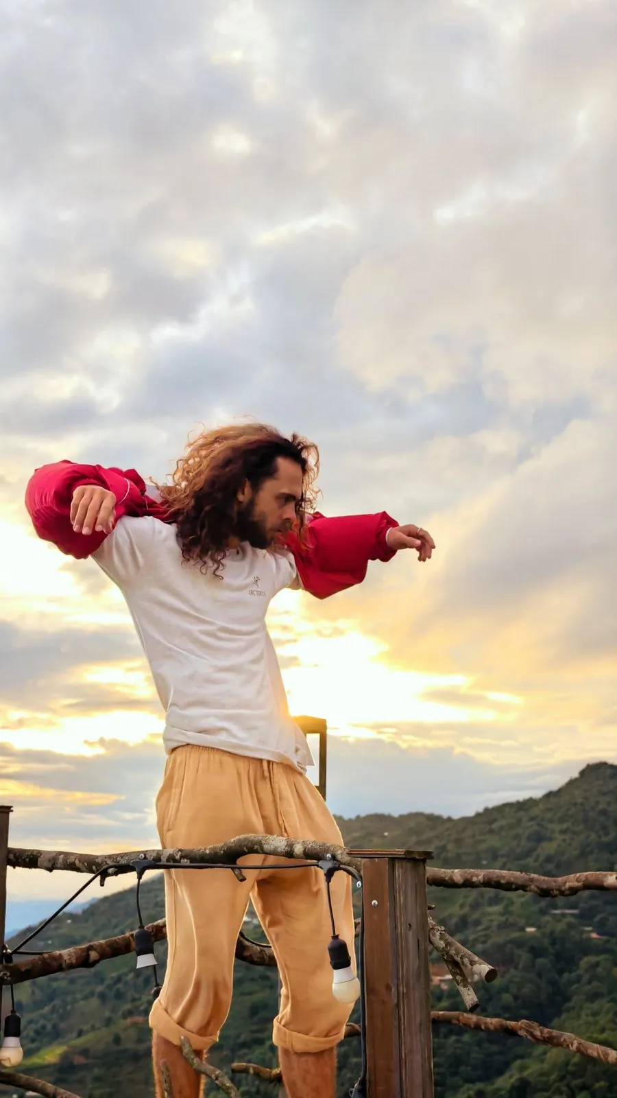Traveler standing on a hillside terrace at sunset