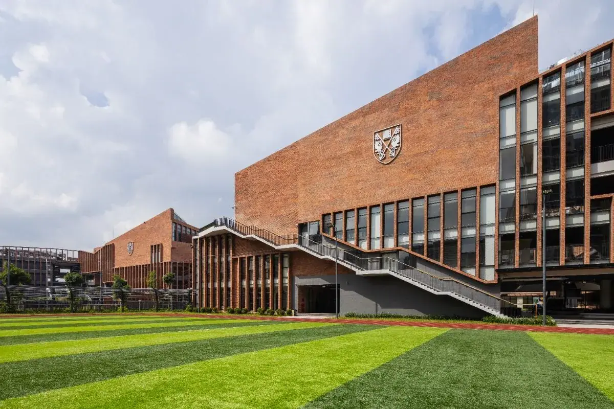 Brick school facade with crest — what tuition really pays for