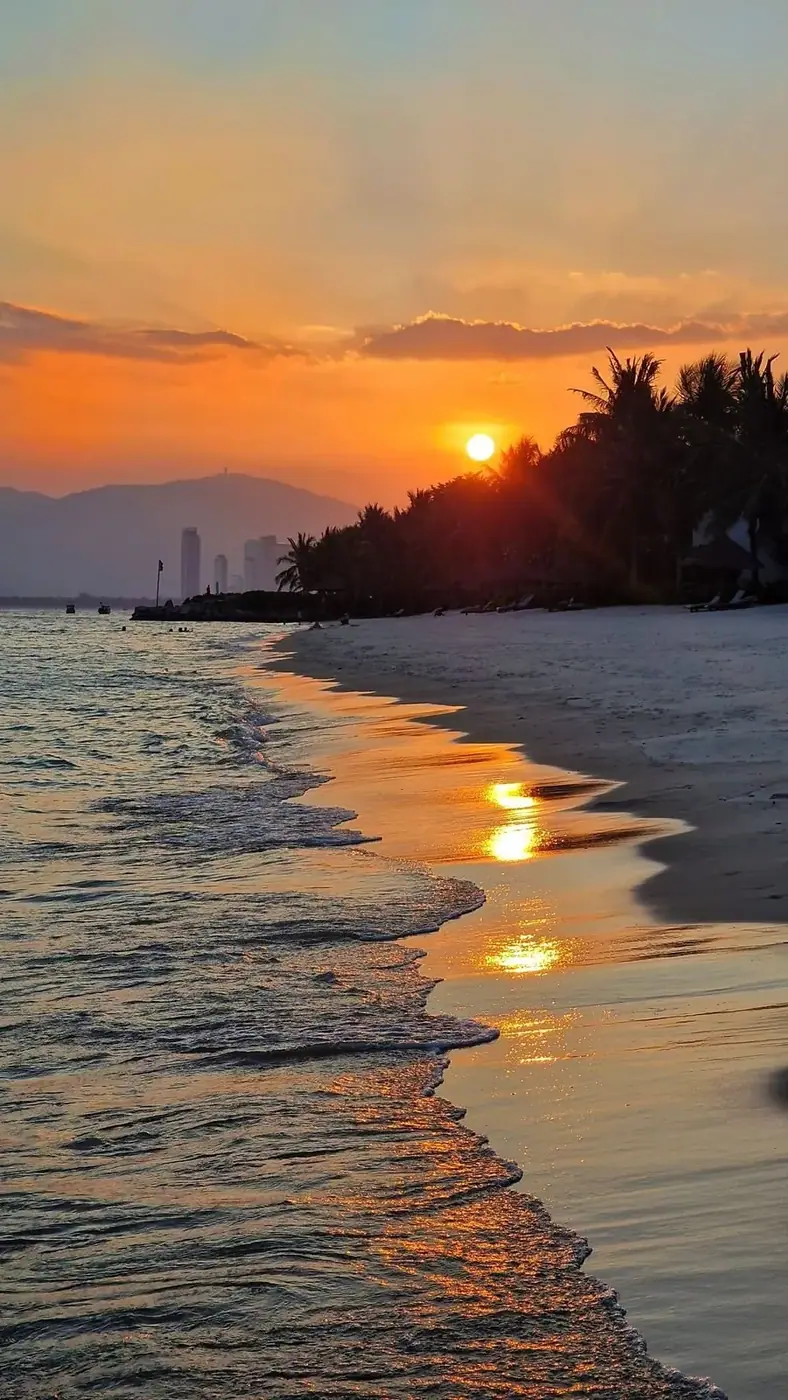 Sunset over Nha Trang beach with the city skyline in the distance