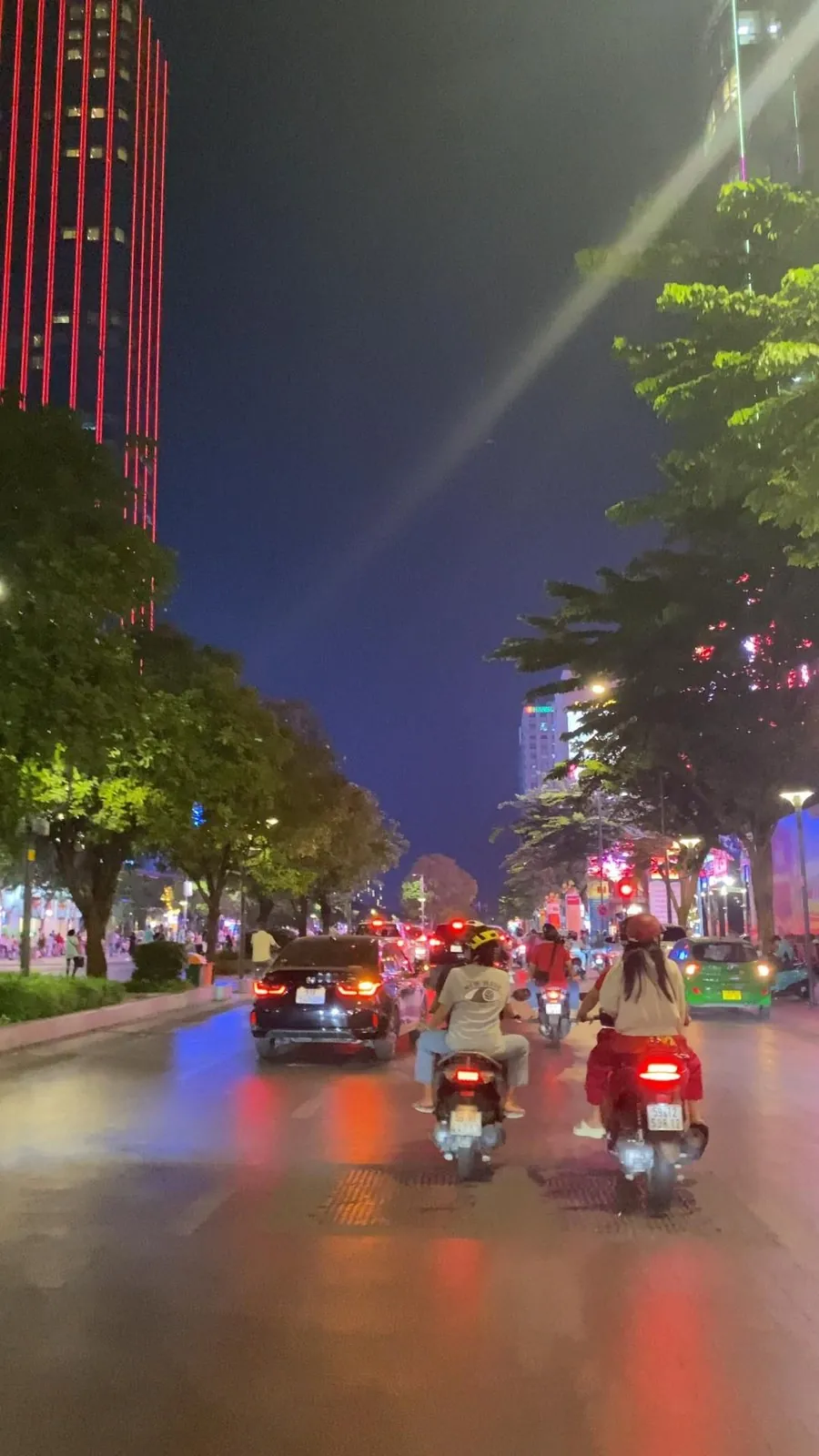 Two riders on motorbikes in Ho Chi Minh City traffic