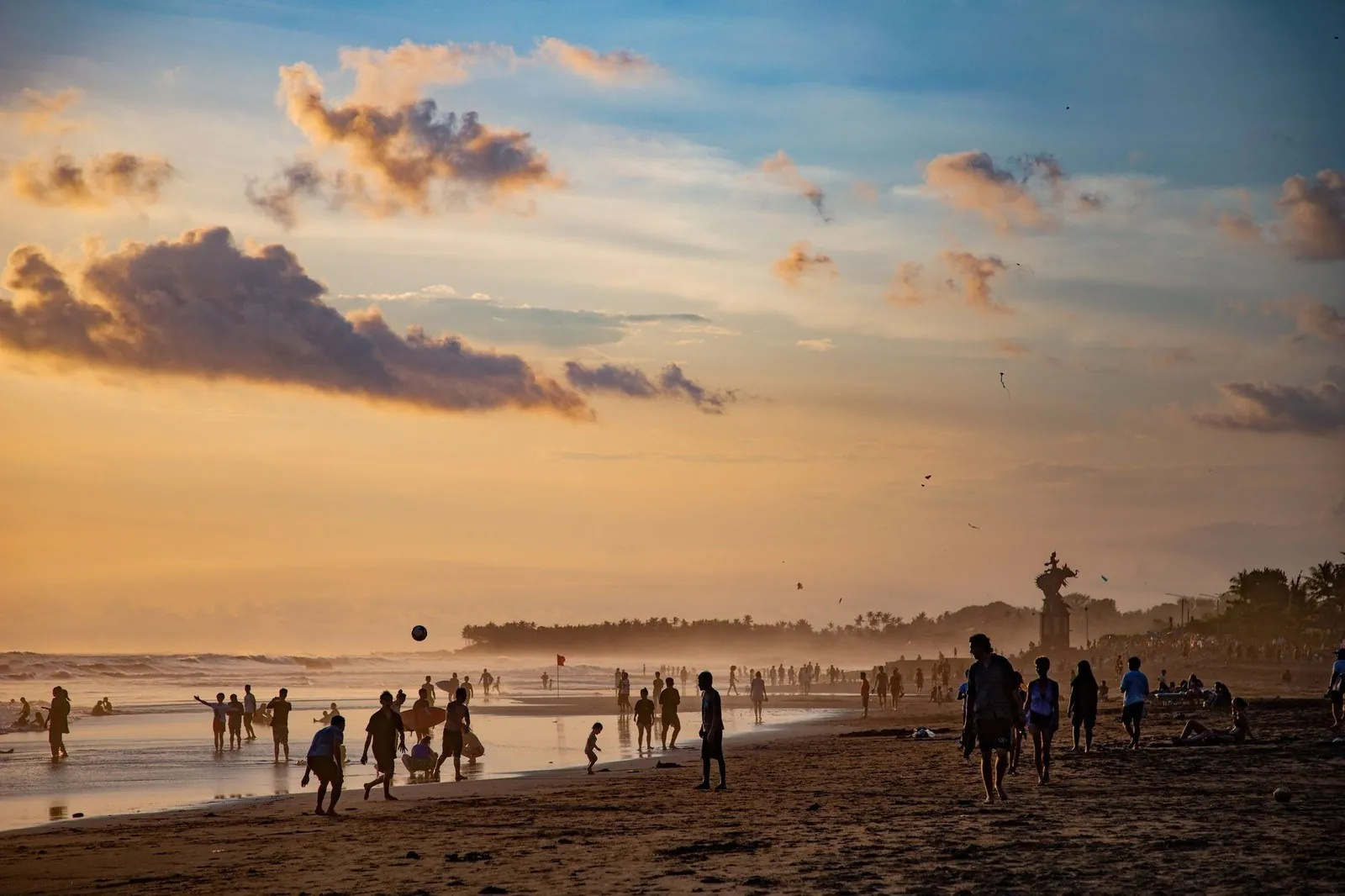 Crowds of people on a busy Bali beach at sunset