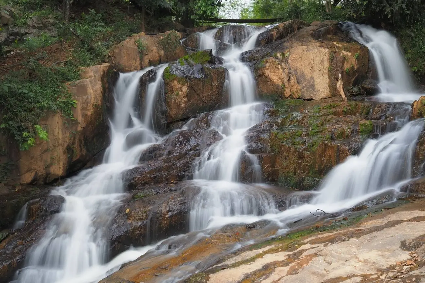 Small forest waterfall cascading over rocks near Dalat