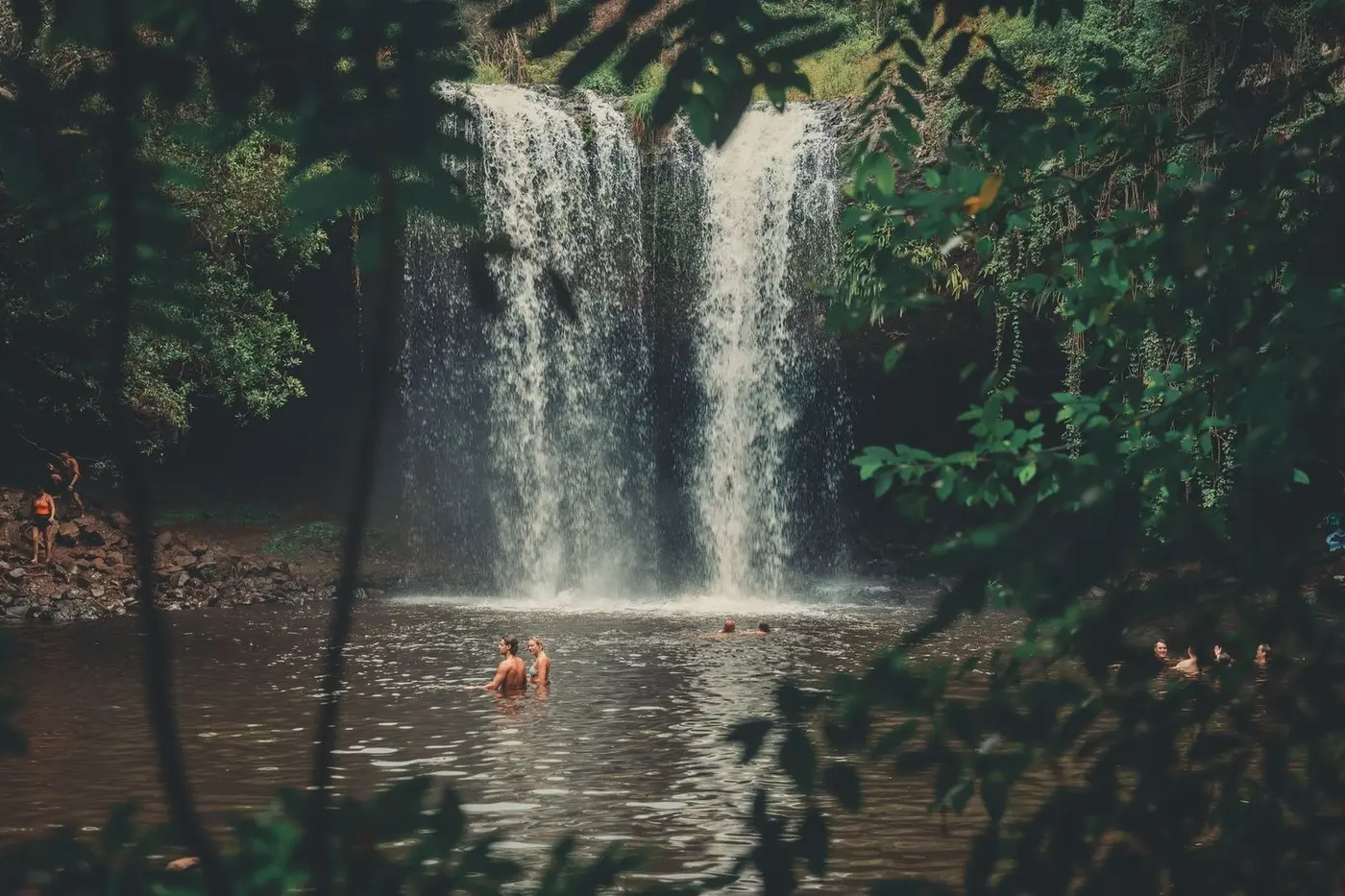 Travelers swimming at a jungle waterfall in Vietnam