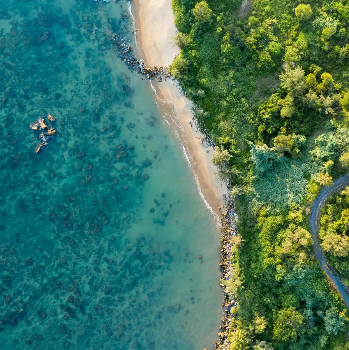 Aerial view of a turquoise coastline near Da Nang with a coastal road
