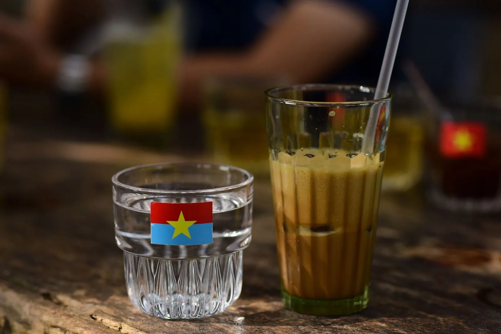 Traditional iced Vietnamese coffee served with a glass of water at a street-side table