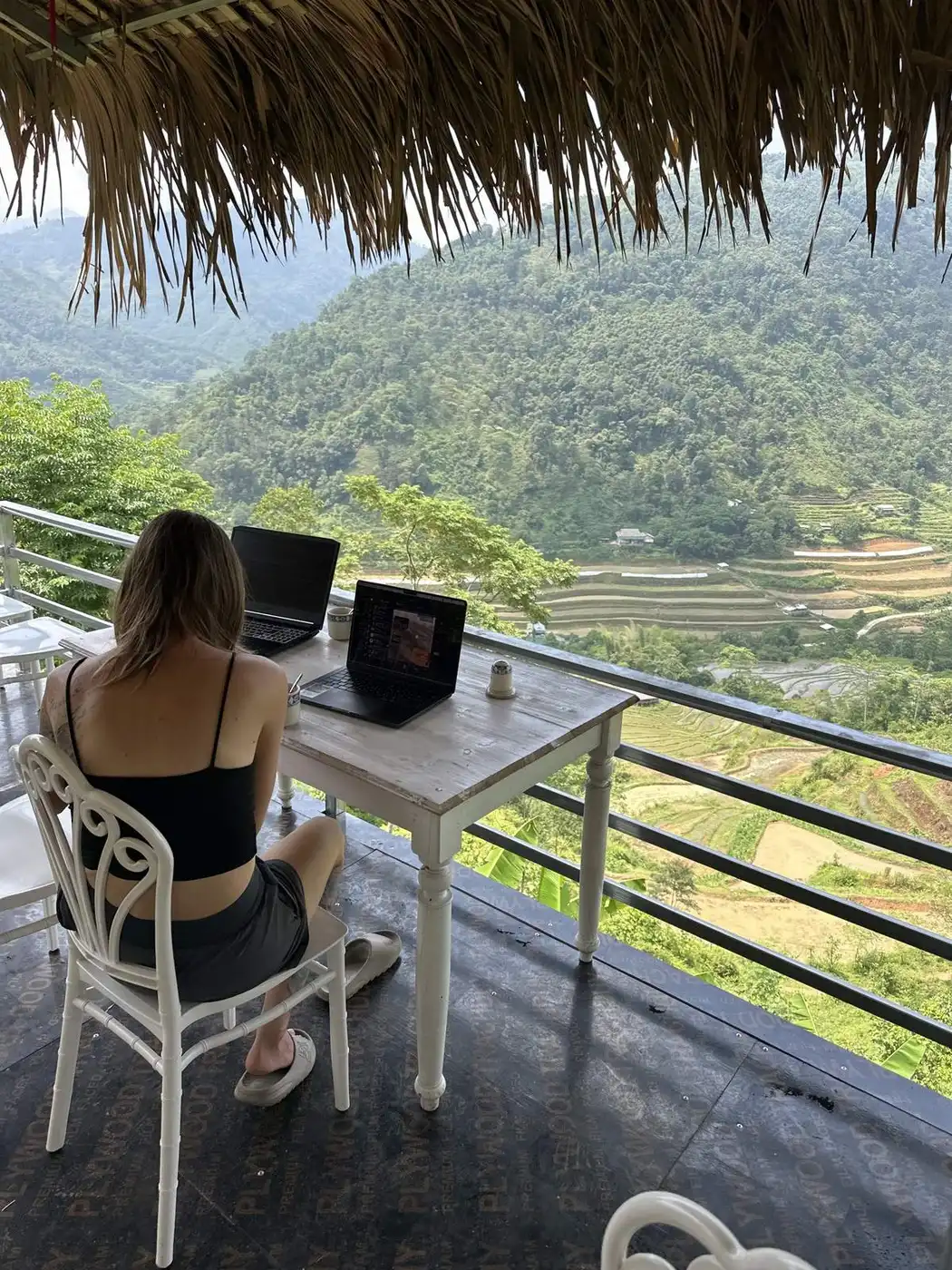Table with two laptops on a Sapa cafe terrace above the rice terraces