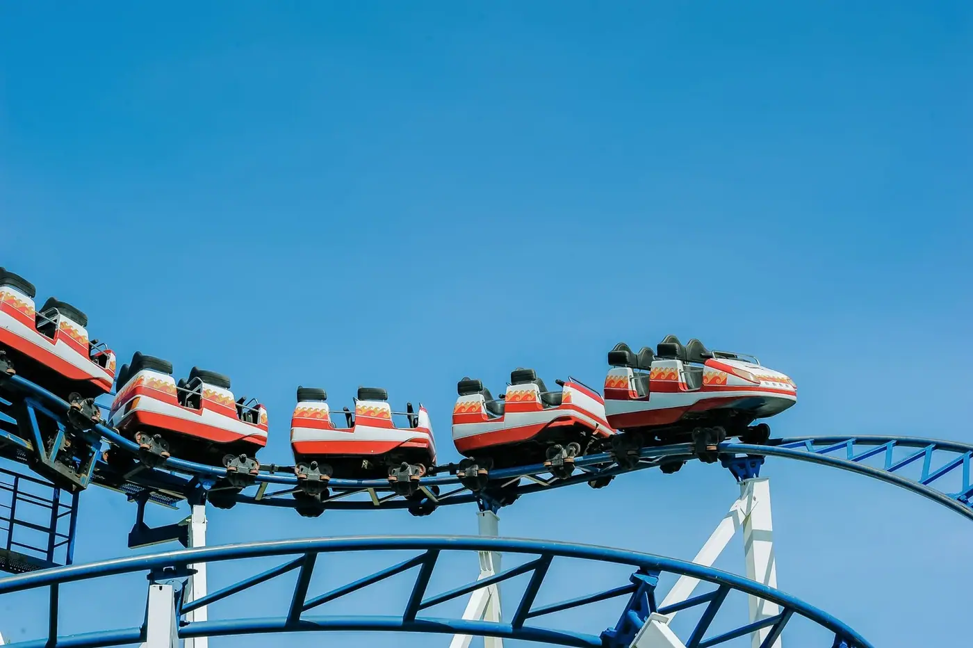 Colorful roller coaster ride against a clear blue sky