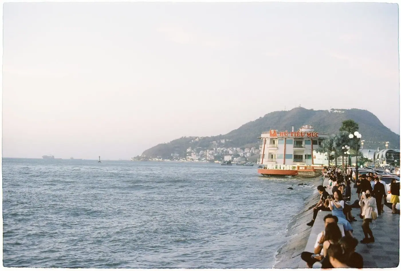People walking coastal promenade at evening Vietnam