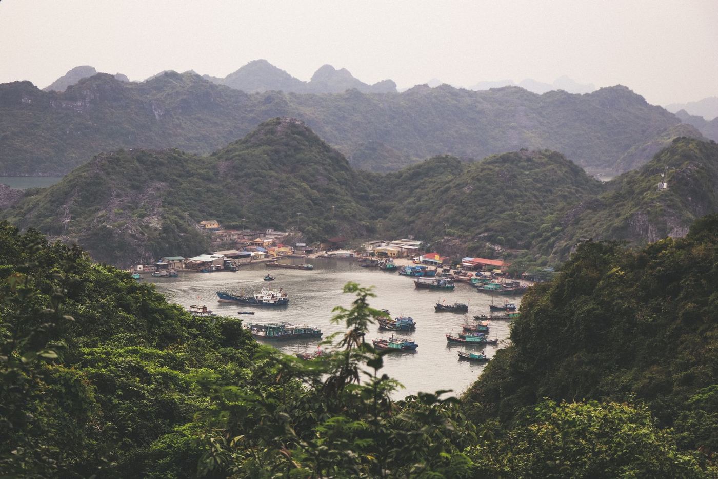 Fishing boats among green limestone karst islands in Vietnam